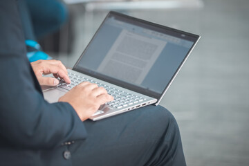 man using a laptop taking notes during a seminar presentation