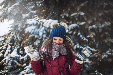 portrait of a beautiful girl in a winter fairy tale. girl playing with snow. joy of winter and snow