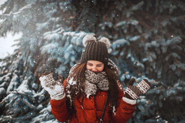portrait of a beautiful girl in a winter fairy tale. girl playing with snow. joy of winter and snow