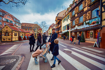 happy people crossing the street of Colmar town during Christmas holidays. Alsace, France - obrazy, fototapety, plakaty