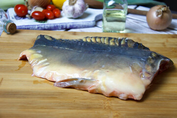 Fresh fish carp fillet with vegetables on a cutting board. 
