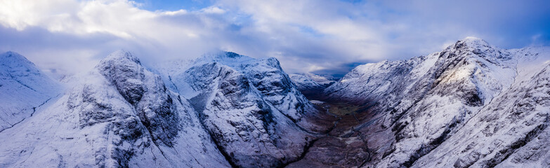 an aerial view of Glen Coe in winter near rannoch moor in the argyll region of the highlands of scotland showing snow dusting on the mountains and munros