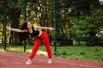 Fitness sport girl in fashion sportswear doing yoga fitness exercise in the street, outdoor sports, urban style