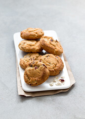 Breakfast vegan oatmeal cookies with dried cranberries on a tray on a light background