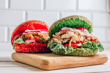 Homemade various chicken burger with colorful buns, kale, red onion, tomato and mayonnaise sauce