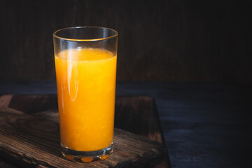 Fresh tangerine or orange juice in glass on table closeup