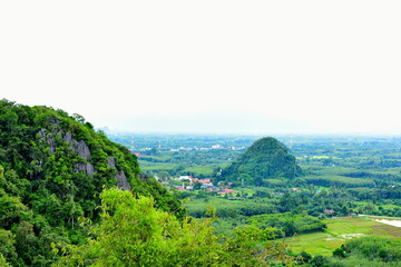 Beautiful scenery and sky with green trees, white and gold clouds. And the mountains before sunset the sunset from the top of the mountain