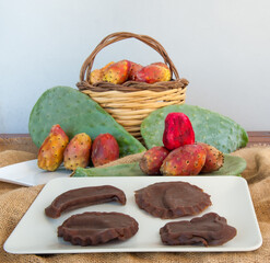 Prickly pears and some mustard shapes on a table with a piece of jute