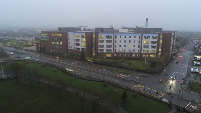 Misty Foggy Hospital Building UK Town Traffic Aerial View Pull Away Slow Descend