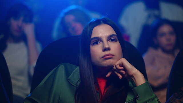 Sad Woman Looking Boring Movie In Cinema. Girl Feeling Unhappy With Bad Movie