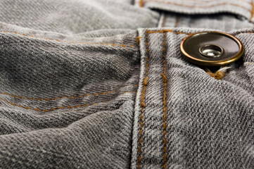 clothing items stonewashed cotton fabric texture with seams, clasps, buttons and rivets, macro