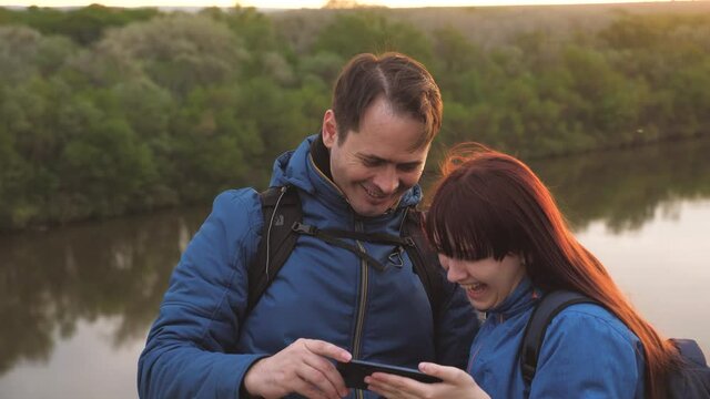 A man and a girl take a selfie on the phone while traveling. Dad and daughter are photographed on a smartphone. A father with a child is looking for adventure in the tourist life. Teamwork. Family