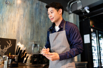 Barista man taking order from customer in cafe.