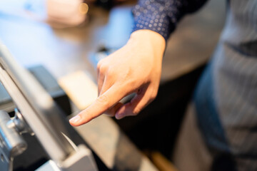 Hand of barista selecting food from digital menu in tablet.