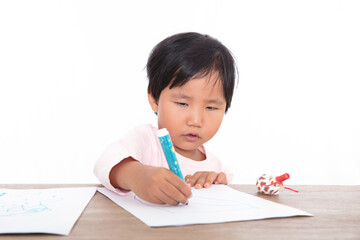 Little girl drawing seriously on the table in front of white background