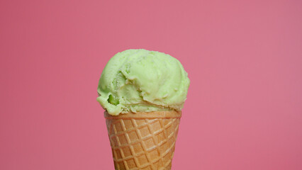 Ice cream lime scoop in waffle cone on pink background, Closeup Front view Food concept.