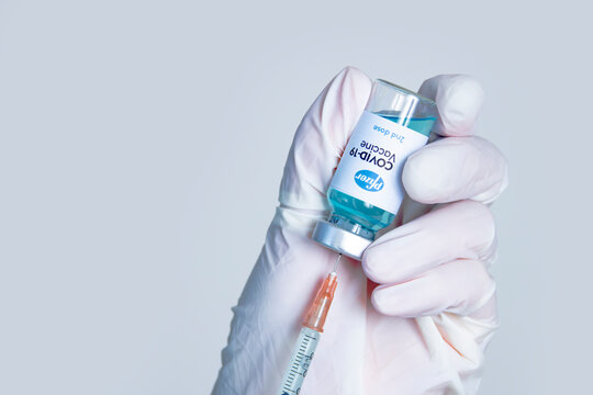 Calgary, Alberta, Canada. Dec 03, 2020. A Health Worker Holding A Syringe And A Vial Vaccine, Getting It Fill With Pfizer Covid-19 Vaccine First Dose On A White Background.