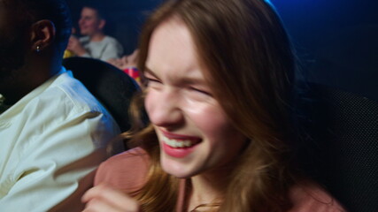 Fototapeta premium Joyful woman laughing in cinema. Cheerful girl having fun in movie theater.