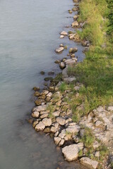 rocky river bank with grass and stones