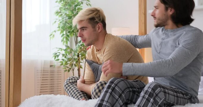 Loving gay man comforting and encouraging sad boyfriend at home