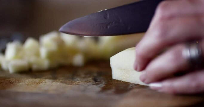 Cutting a freshly peeled pear on a chopping board.