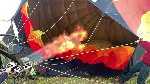 Slow motion of the hot air balloon burner fire while being inflated.