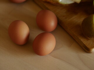 eggs on a wooden table with breakfast - glass of milk, wooden board, break with cheese