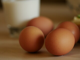 eggs on a wooden table with breakfast - glass of milk, wooden board, break with cheese