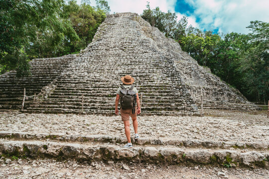 Tourist in the jungle with a backpack and a hat. Tourism in the ancient city Mayan pyramids
