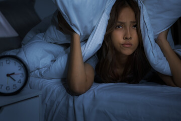 Depressed young woman lying in bed cannot sleep from insomnia