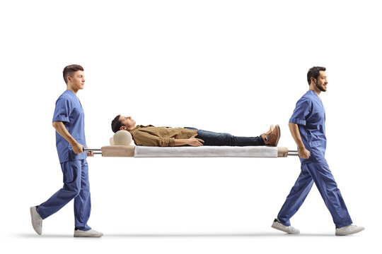 Male health workers carrying young male patient on a stretcher