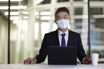 マスクをつけたシニア世代の日本人ビジネスマン