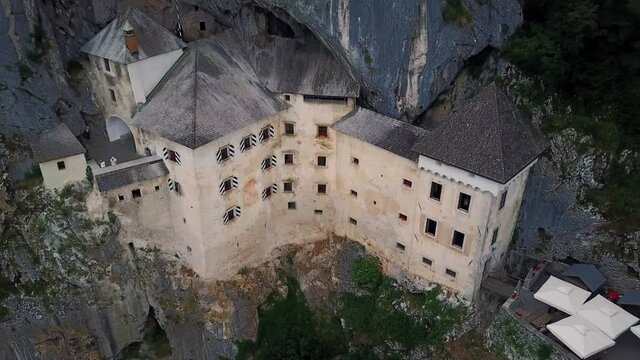 Aerial tilt up, Predjama castle built in a mountain, Slovenian iconic landmark
