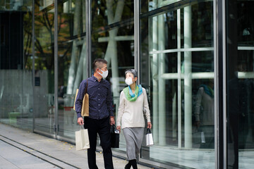 マスクをつけてショッピングを楽しむ日本人シニア夫婦