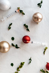 Vaccine syringes and Christmas Decorations for covid holiday concept on white background flatlay