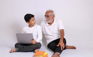 Indian grandfather teaching grandson home schooling or tuition.
