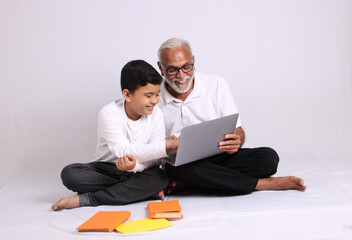 Indian grandfather teaching grandson home schooling or tuition.