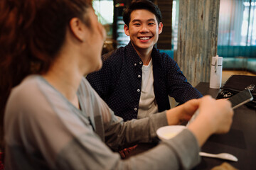 Fototapeta premium Asian business man talking to woman in cafe.