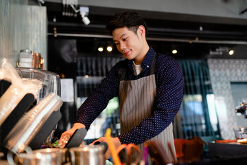 Barista man making coffee with machine behind the bar in cafe.
