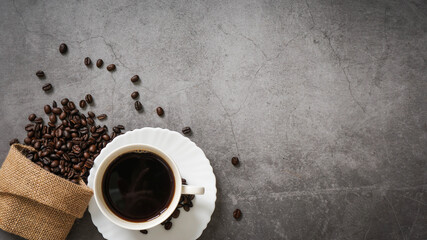 Obraz na płótnie Canvas Coffee cup and beans on old kitchen table. Top view with copyspace for your text