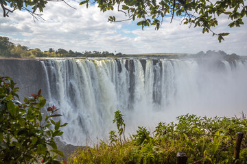 Victoria Falls. Border between Zambia and Zimbabwe. View from the rainforest. Cirrus clouds in the background