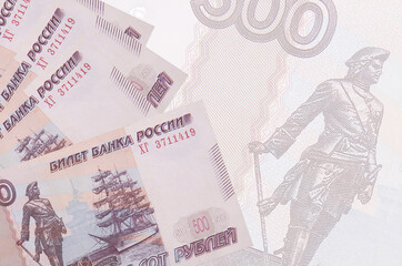 500 russian rubles bills lies in stack on background of big semi-transparent banknote. Abstract...