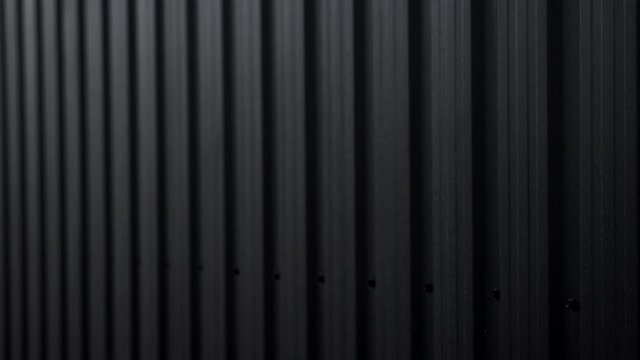 Black Corrugated metal sheet surface of the wall. Galvanize steel background.