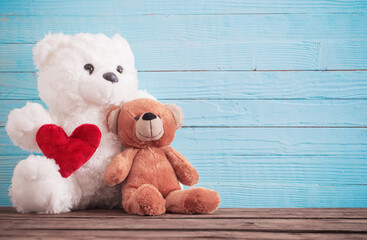Teddy bear with red heart on old wooden background. Valentine's day concept