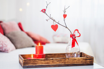 Burning candles on white table in interior. Valentines day concept