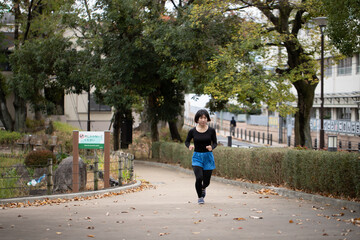 Fototapeta premium 公園でランニングする女性