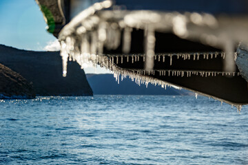 Bottom of ferry ship with icicles in winter on Baikal lake near Olkhon island