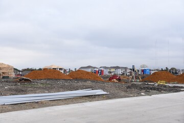 Construction site with concrete, soil, dirt around and crane working