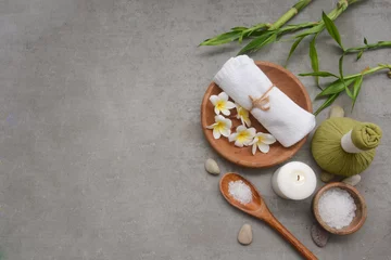Foto op Plexiglas Concept for spa salon, with frangipani, White bath towel and salt in bowl with candle,stone,salt in spoon and bamboo  on gray background, Copy space  © Mee Ting