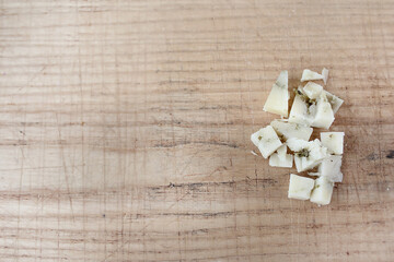 slice cheese on a Board cut delicious farm cheese in parts, in the form of a marble, a plate with different Derby cheeses green